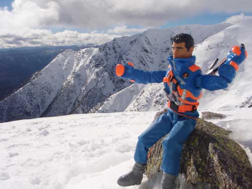 Plastic action figure toy with snow-covered mountains in the background